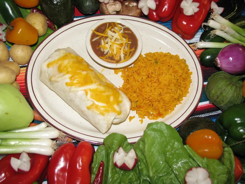 A plate of enchiladas with Mexican rice and beans